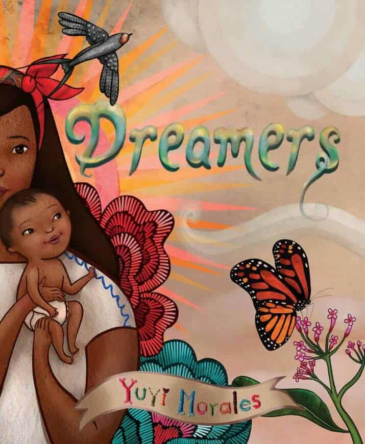 Illustration from the book 'Dreamers' by Yuyi Morales, featuring a mother holding a baby with vibrant floral and butterfly elements in a colorful background.